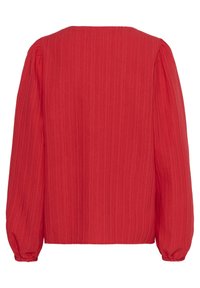 Blouse rouge à manches longues avec un design texturé et côtelé. Présente des manches bouffantes et des poignets élastiqués, offrant une coupe décontractée.