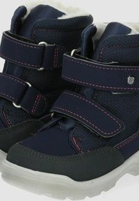 Botas infantiles en color azul marino con parte superior sintética, que cuentan con un suave forro de piel sintética, doble tira de velcro y costuras en rojo contrastante.