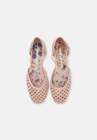 Paire de ballerines tissées rose pâle avec brides à la cheville et semelles intérieures à motif floral, vues de dessus sur fond blanc.