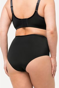 Ensemble de lingerie noir en tissu lisse, avec des bretelles réglables et une fermeture à plusieurs crochets à l'arrière. Design taille haute offrant une couverture complète.