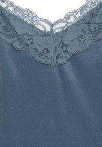 Ljusblått tyg med intrikat spetskant längs halslinningen, med delikata mönster och en slät textur som förbättrar designen.