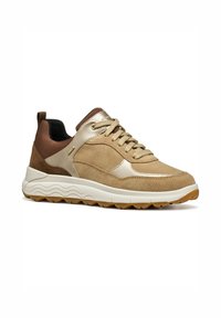 Scarpa sportiva beige con tomaia in suede, dettagli metallici, pannelli laterali testurizzati e intersuola bianca con motivo. Suola in gomma per una maggiore aderenza.