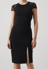 Czarna sukienka bodycon z koronkowymi rękawami, dopasowany krój, długość do kolan, z bocznym rozcięciem, gładka tekstura i minimalistyczny design.