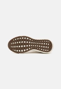 Suola in gomma marrone con un motivo a diamante e bordi bianchi lisci. Progettata per trazione e flessibilità, realizzata con materiali duraturi.