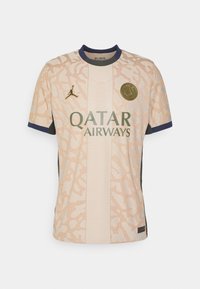 Světle béžový fotbalový dres s texturovaným vzorem, tmavě modré akcenty na rukávech, logo Jordan a nápis "QATAR AIRWAYS" v zelené barvě.