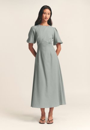 Hellblaues, knielanges Kleid mit Puffärmeln, tailliertem Schnitt und einem fließenden Rock. Glatte Textur; einfaches, elegantes Design.