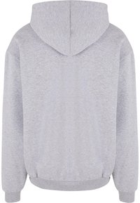 Pelēks kapucis izgatavots no maiga kokvilnas maisījuma auduma. Tam ir ietilpīga kapuce, ribotie piedurkņu gali un apakšmala, kā arī brīvs piegriezums bez redzamām rakstāmām dekorācijām.