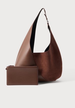 Brown leather and suede hobo bag with a matching rectangular zippered pouch set against a neutral background.