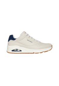 Skechers sneaker with a light beige upper, navy accents, perforated design, white sole, and visible air cushioning in the heel.
