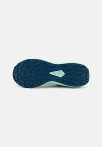 Semelle en caoutchouc bleue avec un design texturé et des crampons agressifs pour l'adhérence. Intercalaire de couleur claire avec une finition lisse.