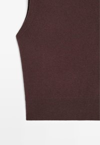 Top in magenta senza maniche in maglia con una texture liscia e bordi a coste, caratterizzato da un taglio dritto e linee pulite. Nessun ulteriore dettaglio.