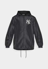 Casaco preto com fecho éclair e capuz, apresentando punhos elásticos, bainha com cordão e um logótipo branco dos New York Yankees no lado esquerdo do peito. Feito de material liso.