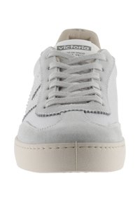 Sneaker bianche in suede e pelle, con suola spessa, punta tonda e lacci piatti. Sottile cucitura che accentua i bordi.