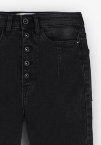 Jeans in denim nero con cinque bottoni frontali, passanti per cintura e tasca frontale con dettagli in rivetto su uno sfondo semplice.