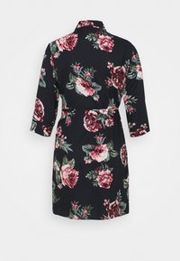 Abito nero a fantasia floreale con maniche a tre quarti, vita con cintura e colletto. Presenta tonalità di rosa e verde nel design.