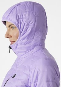 Pro�šívaná purpurová bunda s kapucí a zipem, kterou vyznačuje hladká textura a přiléhavý střih. Kapuce má úzký otvor.