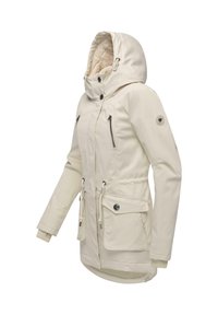 Beige vattentät jacka med foder av päls i huvan, dubbla dragkedjefickor, dragsko i midjan och ribbade ärmslut, med en rund logotyp på ärmen.