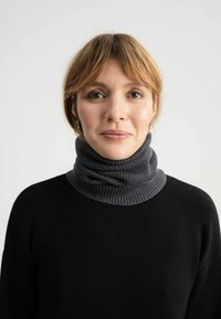 Zwarte trui met een grijze ribgebreide col, met een zachte textuur en een losse pasvorm. De col is gelaagd en omgevouwen.