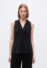 Μαύρο αμάνικο τοπ με βαθύ V-λαιμόκοψη και απαλή υφή, με χαλαρή εφαρμογή και μινιμαλιστικό σχέδιο, κατάλληλο για ευέλικτο στυλ.