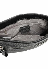 Borsa in pelle nera con un'esterno testurizzato. L'interno presenta una fodera grigia con un motivo geometrico, inclusa una tasca con zip e un'etichetta del marchio.