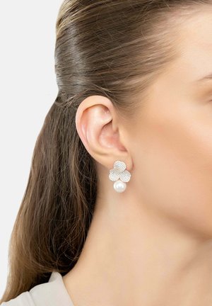 Orecchini a forma di fiore in argento con cristalli scintillanti e una goccia di perla bianca, progettati con una finitura lucida e dettagli delicati.