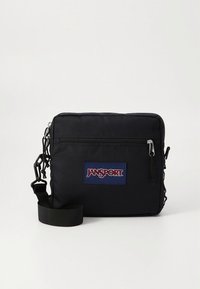 Crna Jansport torba preko ramena s glatkom tkaninom, prednjim džepom na patentni zatvarač, podesivim remenom i logotipom na prednjoj strani.