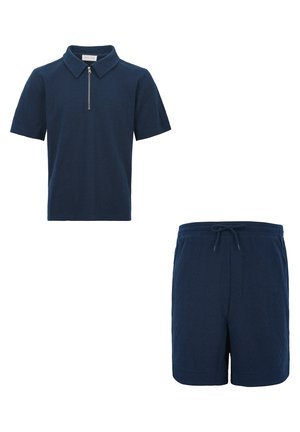 Polo azul marino de manga corta con cremallera frontal y patrón texturizado, combinado con pantalones cortos con cordón a juego y la misma textura.
