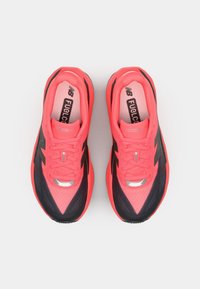 Des chaussures de course roses et noires avec une tige en maille, une semelle rembourrée, des accents réfléchissants et un design élégant. Lacets en rose assorti.
