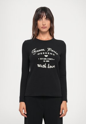 T-shirt nero a maniche lunghe con grafica bianca che riporta il testo "From Paris Weekend Established in 1993 With Love." Texture morbida e liscia.