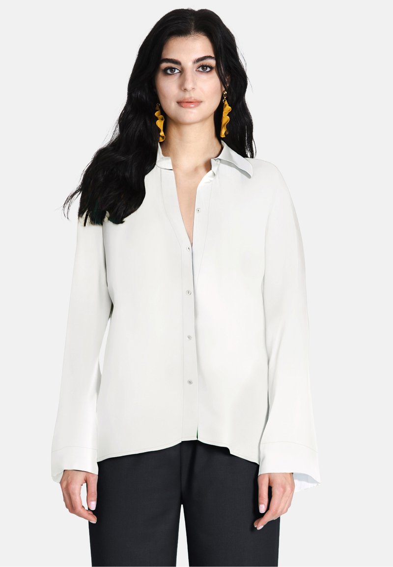 Witte blouse met knopen, een kraag, lange mouwen en een rechte snit. Glad materiaal met een iets losse pasvorm. Minimalistisch ontwerp.