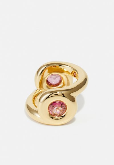 Anello d'oro con un design vorticoso, caratterizzato da due pietre rotonde e sfaccettate di colore rosa incastonate nel design. Texture liscia e finitura lucida.