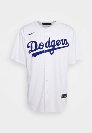 Wit baseballshirt met knopen, met "Dodgers" in blauwe script op de borst en een blauwe Nike-swoosh aan de bovenkant van de rechterkant.