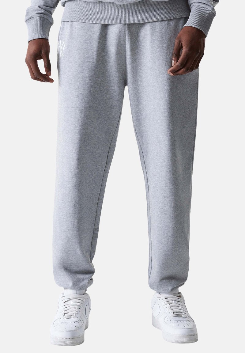 Graue Jogginghose aus weichem Stoff mit einem elastischen Bund, ausgestattet mit Seitentaschen und einem enganliegenden Bündchen an den Knöcheln.