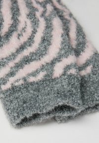 Sciarpa grigia lavorata a maglia con motivo a zebra rosa, caratterizzata da una superficie testurizzata e soffice e da una leggera lucentezza che aumenta l'interesse visivo.