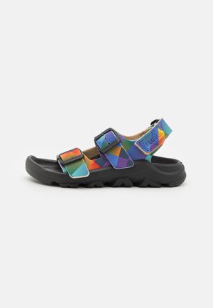Sandale à bout ouvert avec semelle noire épaisse et brides à motif géométrique coloré avec boucles noires réglables.
