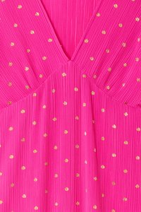 Fuchsia dress featuring vertical pleats, a V-neck design, and gold polka dot detailing throughout the fabric.