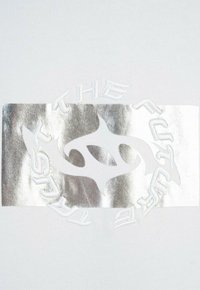 Biały materiał z centralnym prostokątem ze srebrnej folii, na której znajduje się wytłoczone hasło „PRZYSZŁOŚĆ” oraz stylizowany wzór w centrum.