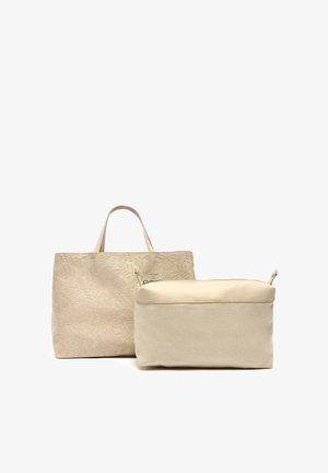 Beige tote väska med blommig präglad yta och korta handtag, tillsammans med en mindre, krämfärgad dragkedjeväska. Båda har en slät textur.