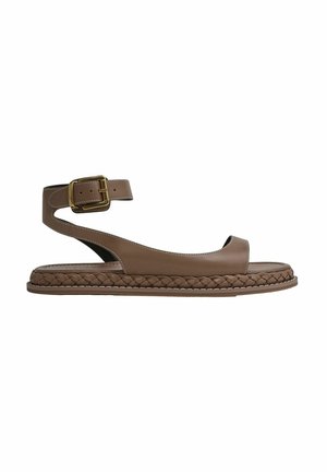 Brune lædersandal med en flet-sål, åben tå og ankelrem med en gylden spænde. Glat tekstur med kontrasterende syning.