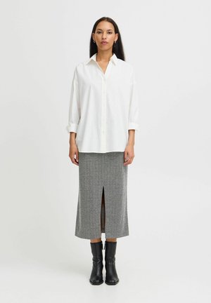 Balta marškinėlių chemise su sukritais rankovėmis, derinama su pilkai raštuota midi sijonu, turinčiu priekinį skeltuką, ir juodais kulkšnies botais.