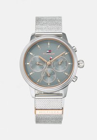 Montre en argent avec un bracelet en argent texturé, cadran gris, accents en or rose, sous-cadrans chronographe et boîtier rond en acier inoxydable.