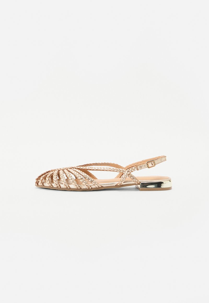 Platte sandaal met vlechtontwerp in goudkleurig materiaal, voorzien van een verstelbare enkelband en een metallic accent op de hak.