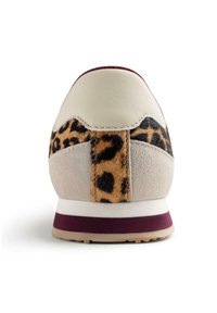 Zapatilla con parte superior de cuero beige y ante gris, con un panel de estampado de leopardo en el talón, detalles en burdeos y suela blanca.