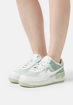 Weiß und mintgrüne Sneaker mit Obermaterial aus Leder und Mesh, runder Zehenbereich, strukturierten Akzenten und markantem Nike Swoosh-Logo. Gummisohle.