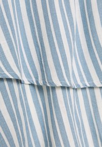 Strisce verticali azzurre e bianche su tessuto con una cucitura orizzontale che crea un sottile effetto a strati.