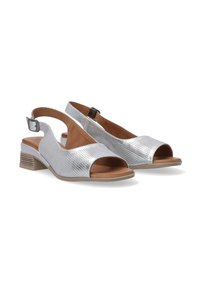 Zilveren slingback schoenen met open tenen, gestructureerd metallic bovenwerk en een lage gestapelde hak. Ontworpen met een verstelbare enkelband.
