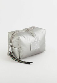 Srebrny pikowany kosmetyczka z podwójnym zamkiem błyskawicznym, kolorowym sznurkiem akcentującym oraz prostokątną etykietą z napisem "APRES SKI DOLOMITI."