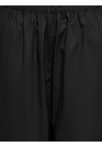 Sorte løstsiddende bukser i stof med elastisk talje og synlige detaljer af en central søm.