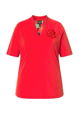 Rød kortærmet V-hals skjorte med et lille tekstureret blomsterdetalje på venstre bryst og en farverig mønstret indvendig krave.