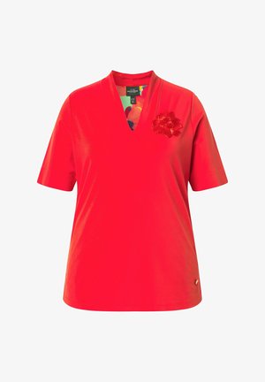 Rotes T-Shirt mit kurzen Ärmeln und V-Ausschnitt, mit kleinem strukturiertem Blumenmotiv auf der linken Brust und einem farbenfrohen gemusterten Innenkragen.
